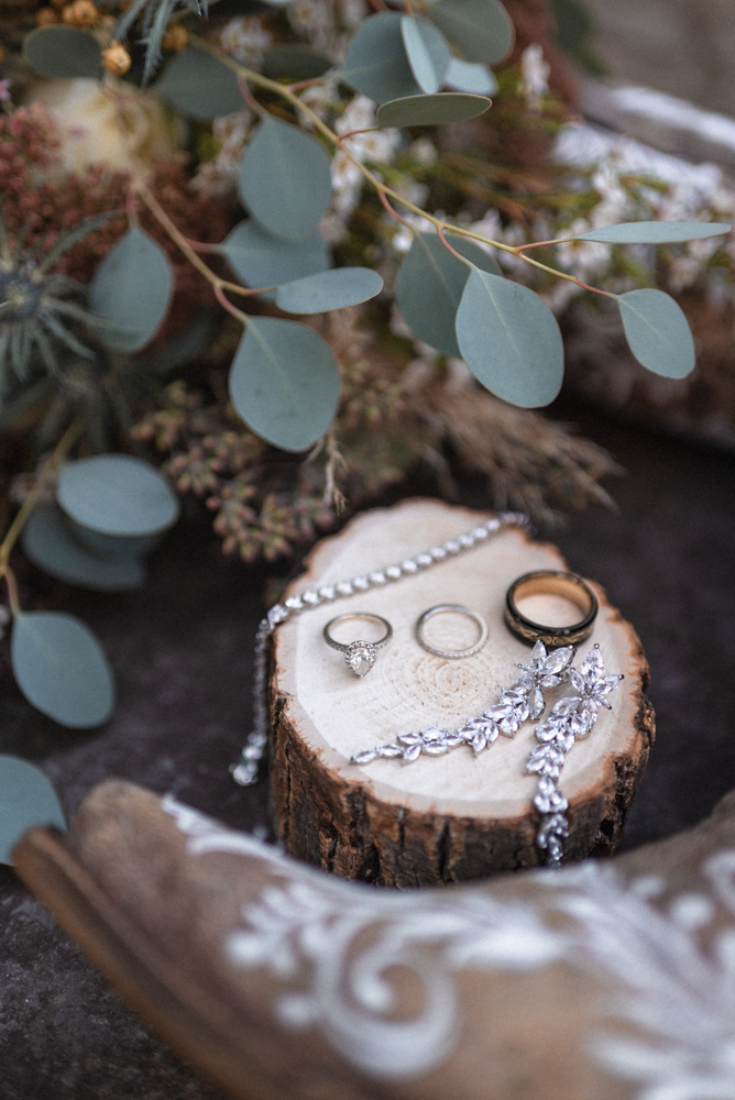 Wedding details set out on display for boho flatlay with natural wood ring box