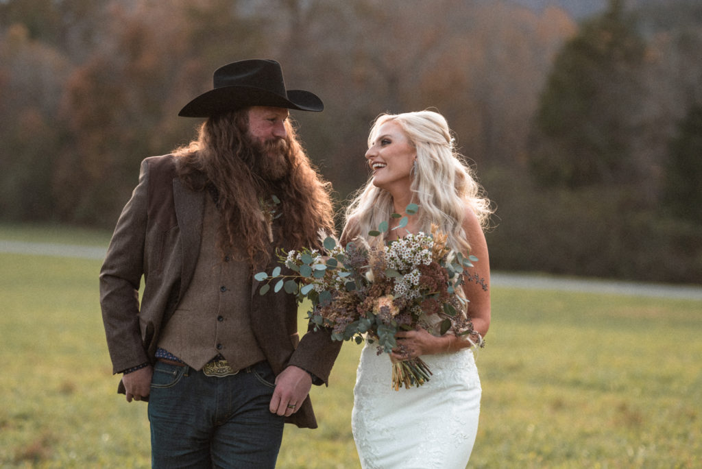 Beautiful boho bride and groom with dried floral and eucalyptus leaf bouquet