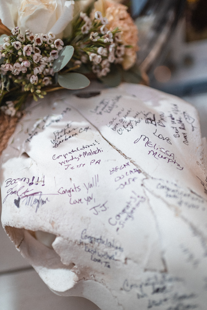 A unique wedding guest book long horn skull with florals and signatures