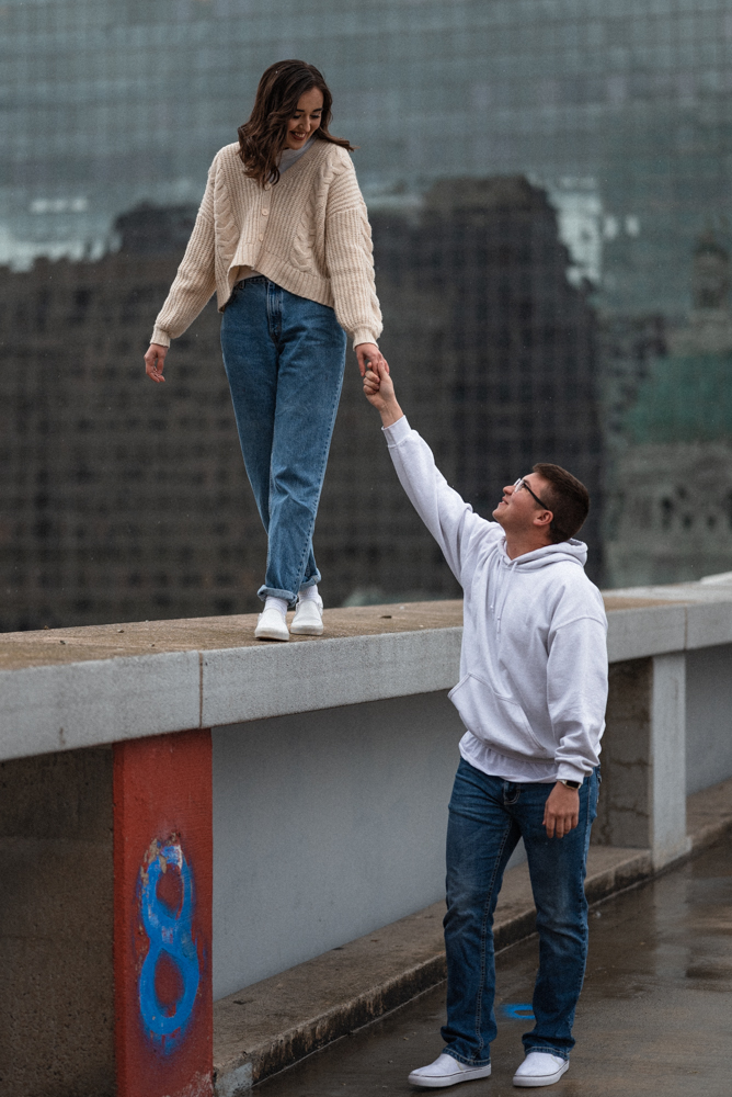 Significant other trusts lover as she walks on parking roof ledge