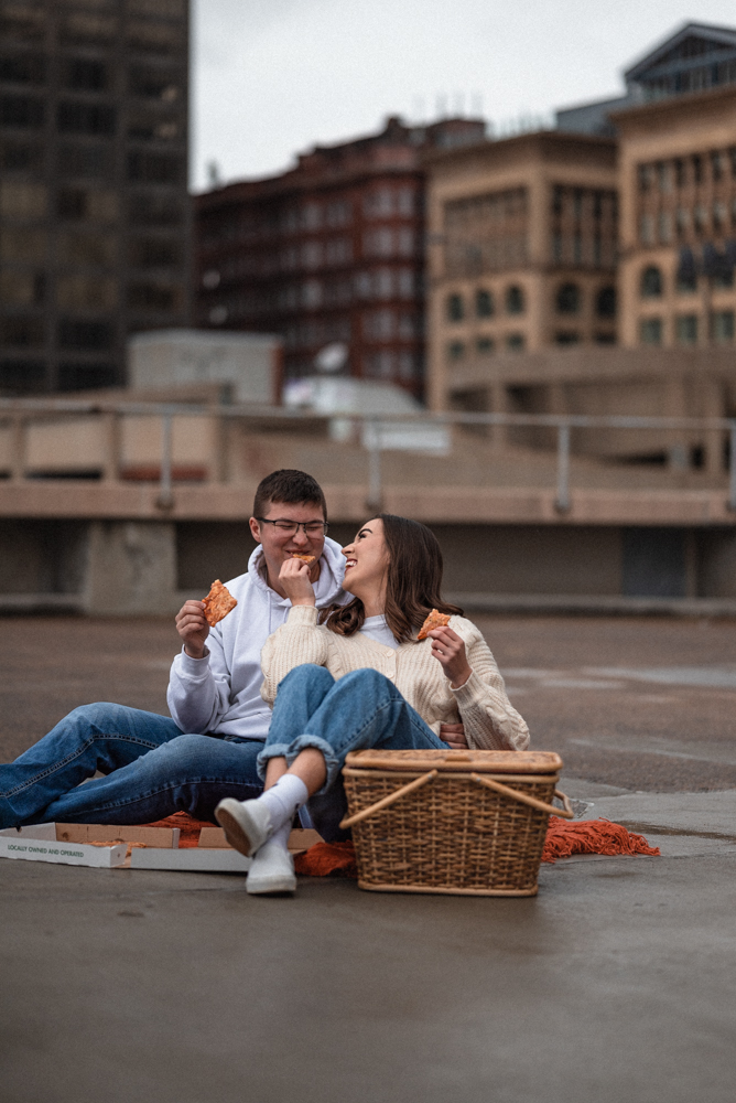Cute couple feeds each other pizza during st louis date night on a rooftop