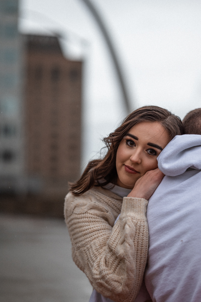 Girlfriend rests her head on boyfriends shoulder during st louis date night after they have enjoyed pizza on their rooftop picnic