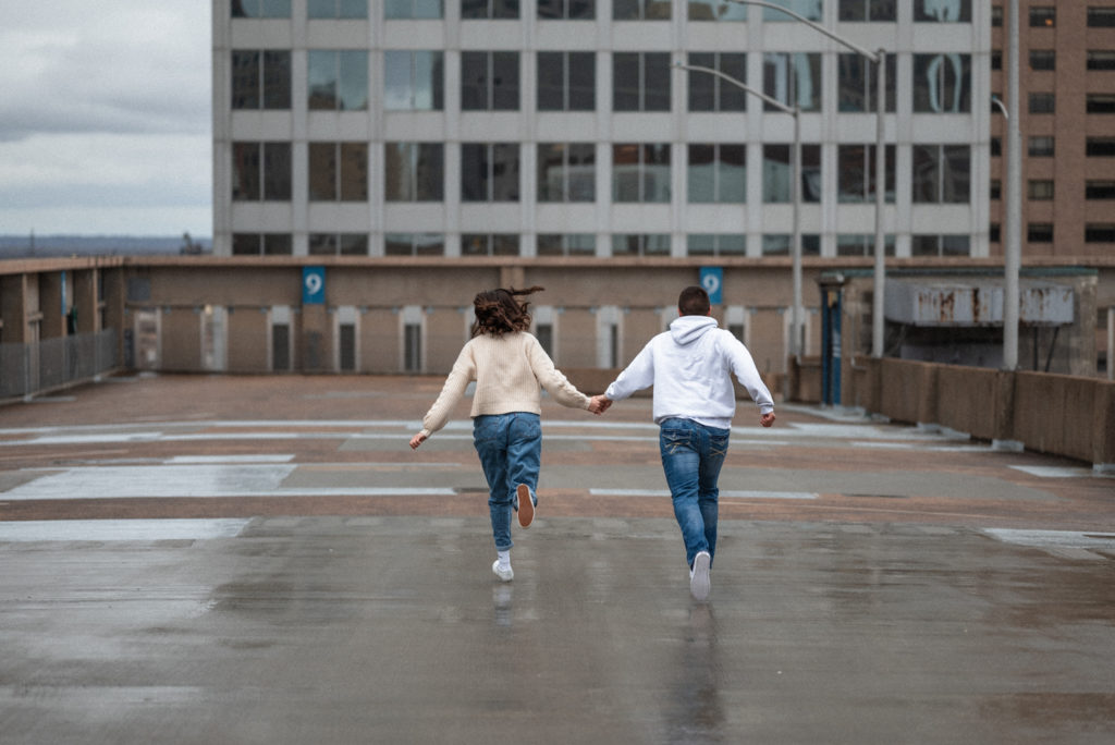 Couple runs through the rain on st louis rooftop during their intimate date night