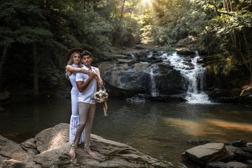 Couple elopes at stunning Georgia waterfall with boho attire and sola wood flowers
