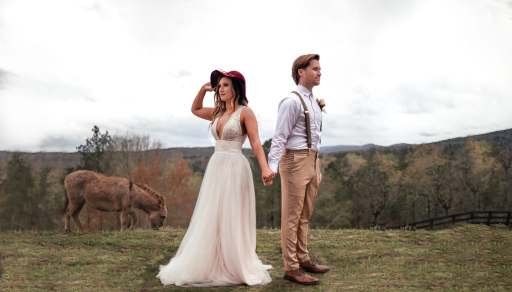 Boho Couple stands in a field overlooking georgia mountains
