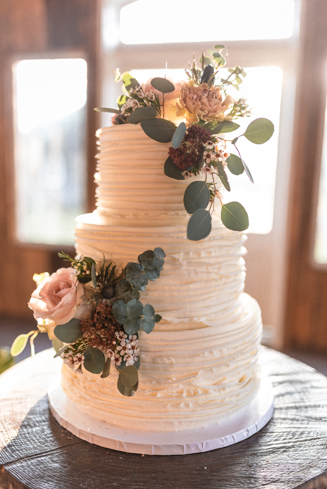 The boho wedding cake with ruffled frost glows in the sunlight
