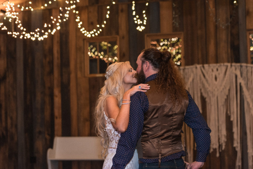 The bride and groom take one final last kiss before their wedding night ends at the barn at high point.
