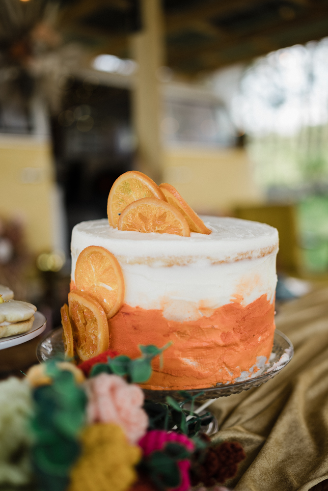 A stunning dreamsicle cake with orange and white frosting garnished with oranges.