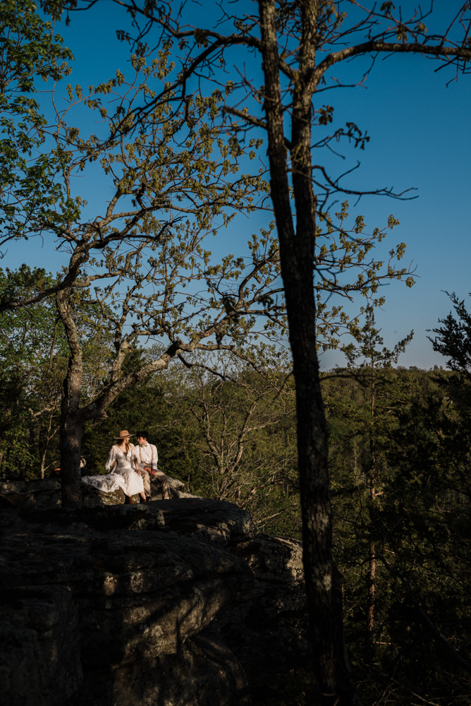 Elopement couple looks into each other's eyes on thinking rock overlooking the Meramec River at lost hill lake wedding venue.